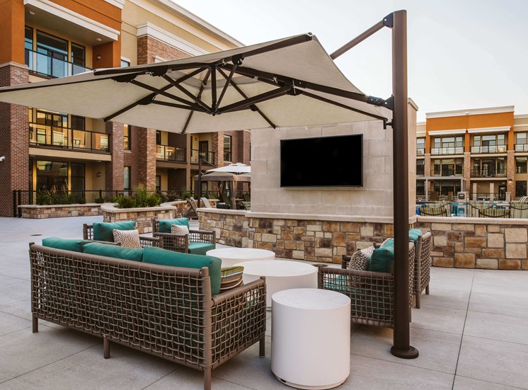 couches under a canapoy at an apartment complex outdoor pool